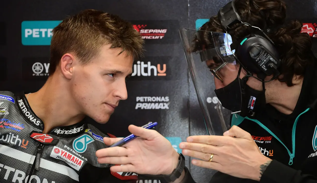 Pembalap Petronas Yamaha, Fabio Quartararo, berbincang dengan teknisinya usai latihan bebas MotoGP Catalunya di Circuit de Barcelona-Catalunya, Jumat (25/9/2020). Pembalab Yamaha, Morbidelli, finish pertama dengan catatan waktu satu menit 39,789 detik. (AFP/Lluis Gene)