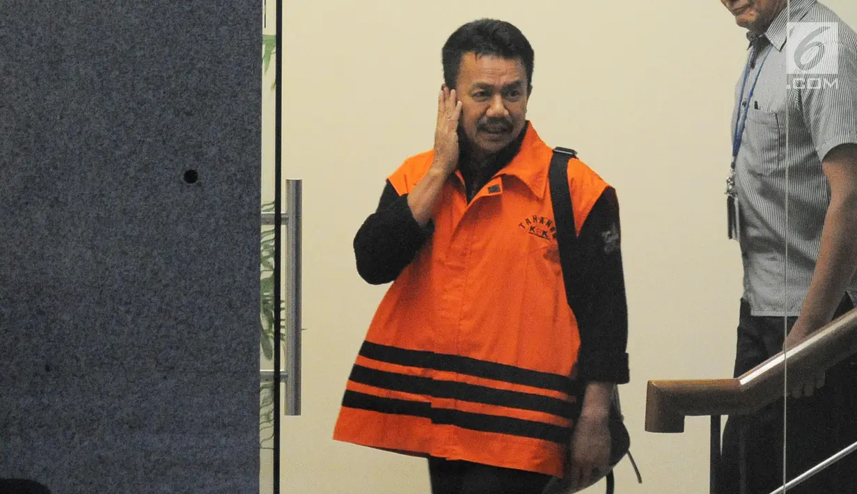 Ekspresi Bupati Jombang Nyono Suharli Wihandoko dikawal petugas berjalan keluar usai menjalani pemeriksaan perdana di Gedung KPK, Jakarta, Rabu (7/2). Nyono ditangkap terkait promosi jabatan di Pemkab Jombang. (Liputan6.com/Herman Zakharia)