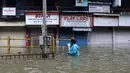 Seorang wanita berjalan melewati jalan yang tergenang air setelah hujan lebat di Mumbai, India, Rabu (23/9/2020). Musim hujan di India berlangsung dari Juni hingga September. (AP Photo/Rajanish Kakade)