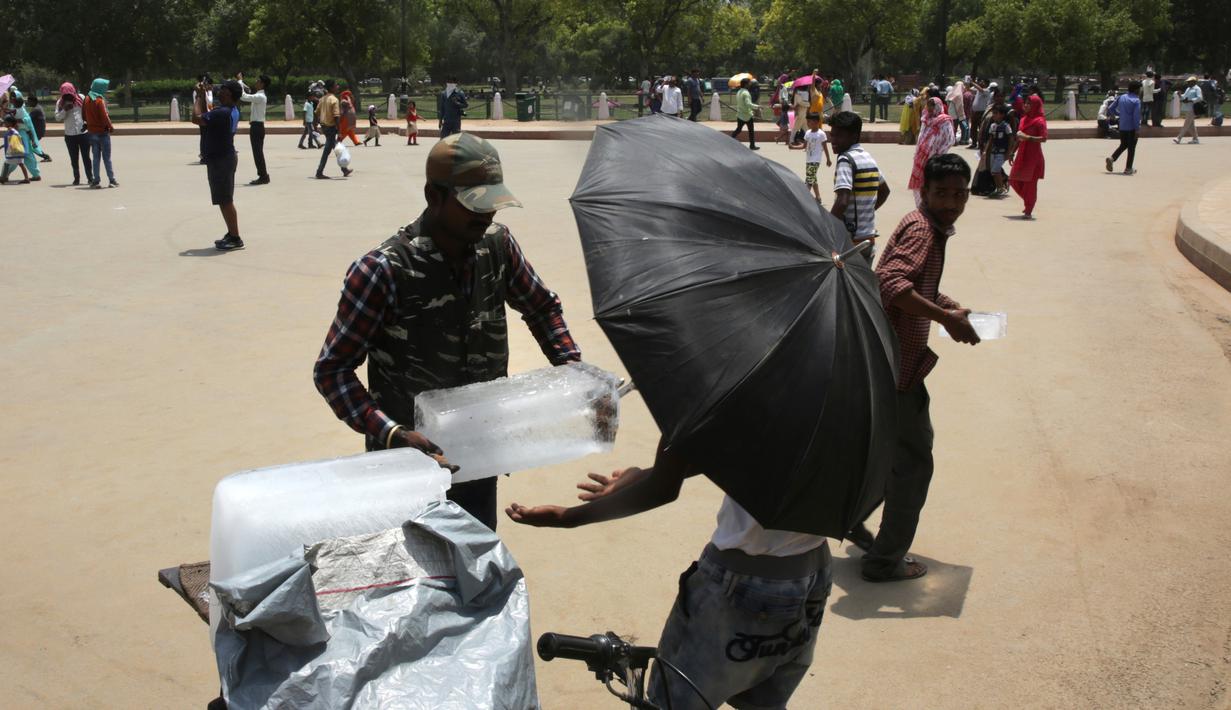 Pedagang membeli es selama musim panas di New Delhi, India (10/6/2019). Kondisi gelombang panas yang parah menyapu bagian utara dan barat India dengan suhu maksimum melonjak hingga 48 derajat Celcius ( 118 F) di beberapa bagian Rajasthan. (AP Photo/Manish Swarup)