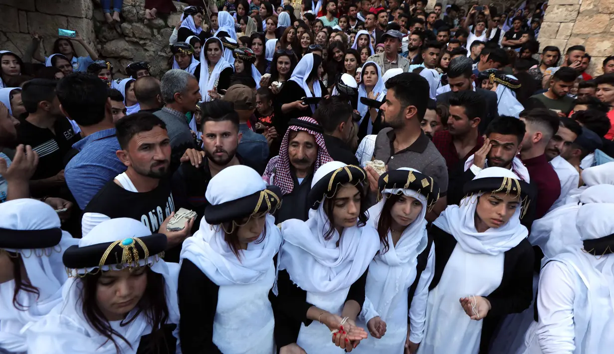 Ratusan orang dari kelompok Yazidi Irak berkumpul di luar kuil Lalish untuk merayakan Tahun Baru Yazidi di lembah dekat Dohuk, Irak (17/4). Mereka adalah kelompok etnoreligius dan berbahasa Kurdi yang mempraktikkan agama sinkretisme. (AFP/Safin Hamed)