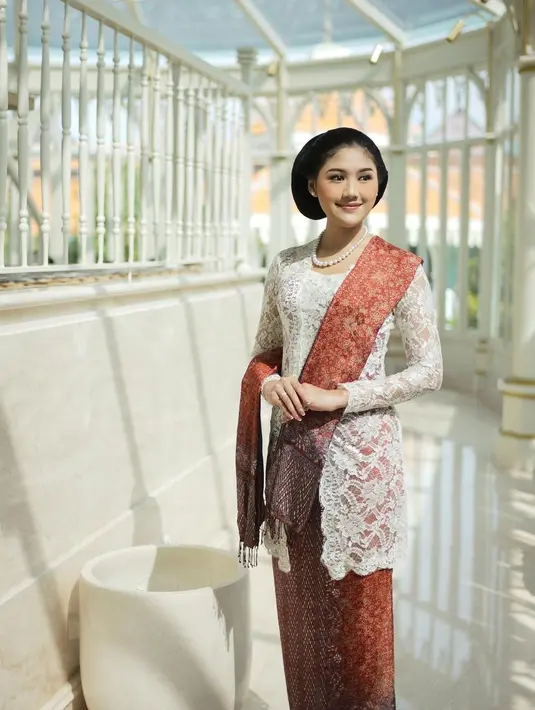 Erina Gudono menawan dalam balutan kebaya panjang berwarna putih. Kebaya sederhana dengan motif brokat yang super cantik, dipadukan dengan selendang dan bawahan dari kain batik yang sama, berwarna merah dengan motif keemasan. Foto: Instagram.