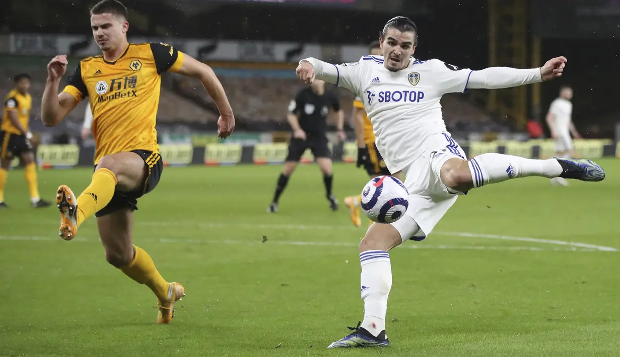 Bek Leeds United, Pascal Struijk (kanan) melepaskan tendangan dibayangi seorang pemain Wolverhampton Wanderers, dalam laga Lanjutan Liga Inggris 2020/21 pekan ke-25 di Molineux Stadium, Jumat (19/2/2021). Leeds kalah 0-1 dari Wolverhampton. (AP/Nick Potts/Pool)