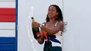 Petenis Jepang, Naomi Osaka menyemprotkan sampanye menyemprotkan sampanye merayakan gelar juara tunggal putri Australia Terbuka 2019 di Pantai Brighton Melbourne, Australia, Minggu (27/1). (AP Photo/Kin Cheung)