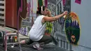 Seniman grafiti Sandra Fabara atau lebih dikenal Lady Pink melukis mural di Casita Maria, Bronx, New York, AS, Minggu (2/6/2019). Lady Pink dikenal juga dengan julukan 'The First Lady of Graffiti' atau 'Ibu Negara Grafiti'. (Don Emmert/AFP)