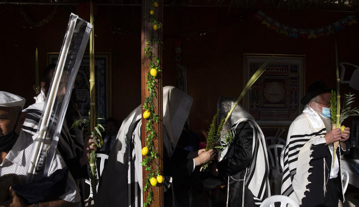 Pria Yahudi Ultra-Ortodoks berdoa selama hari raya Yahudi Sukkot di Tembok Barat, situs paling suci di mana orang Yahudi dapat berdoa di Kota Tua Yerusalem, Rabu (22/9/2021).  (AP Photo/Sebastian Scheiner)