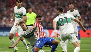 Bek Elche asal Austria #22, David Affengruber, terjatuh di samping penyerang Atletico Madrid asal Italia #22, Giacomo Raspadori, dalam pertandingan Liga Spanyol antara Club Atletico de Madrid dan Elche CF di Stadion Metropolitano, Madrid,&nbsp;Minggu (24-8-2025) dini hari WIB. (Thomas COEX/AFP)