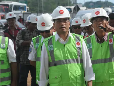 Menteri Perhubungan Budi Karya Sumadi memantau lokasi pembangunan kereta layang (Light Rail Transit/LRT), rute Cawang-Cibubur di tol Jagorawi Km 13, Jakarta, Minggu (8/1). LRT akan melewati 18 stasiun dengan panjang 42,1 km. (Liputan6.com/Helmi Afandi)