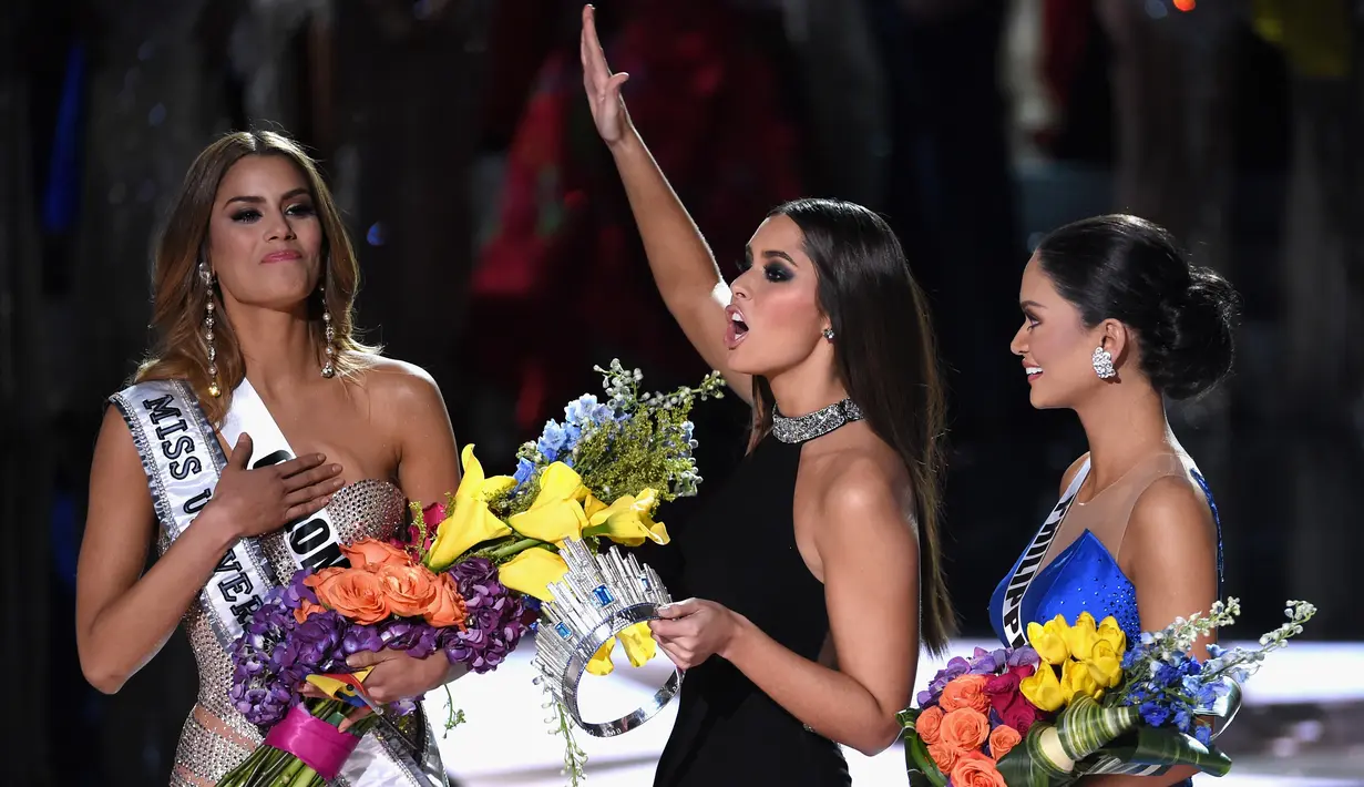 Miss Universe 2014, Paulina Vega saat mengambil kembali mahkota yang sempat disematkan ke Miss Kolombia, untuk diberikan kepada Miss Universe 2015, Pia Alonzo Wurtzbach di The AXIS Las Vegas, AS, Minggu (20/12). (Ethan Miller/Getty Images/AFP)