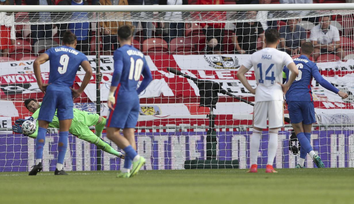 Gelandang Inggris, Jordan Henderson (kanan) melakukan eksekusi penalti yang mampu digagalkan kiper Rumania, Florin Nita dalam laga uji coba menjelang berlangsungnya Euro 2020 di Riverside Stadium, Middlesbrough, Minggu (6/6/2021). Inggris menang 1-0 atas Rumania. (AP/Scott Heppell/Pool)