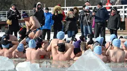 Orang-orang mengambil gambar penggemar renang es di Danau Zalew Zegrzynski di Nieporet, Polandia, Minggu (25/2). Kini, Polandia bersuhu -8 derajat Celsius pada siang dan turun ke -16 derajat Celcius di malam hari. (AP Photo/Alik Keplicz)