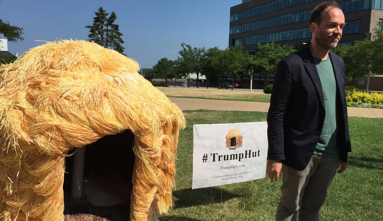 Seorang pria berdiri disamping gubuk yang menyerupai rambut Donald Trump di Cleveland, 19 Juli 2016. Gubuk 'Trump Hut' itu bentuk sindiran kepada Trump yang diyakini bisa memperbesar kesenjangan sosial di AS bila terpilih menjadi presiden. (Nova SAFO/AFP)
