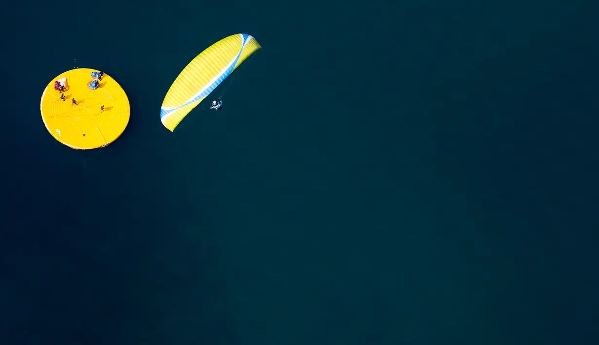 Paraglider mendekati target mengambang saat acara "Acro Show" di atas Danau Jenewa di Villeneuve Swiss (20/8). (Valentin Flauraud / Keystone via AP)