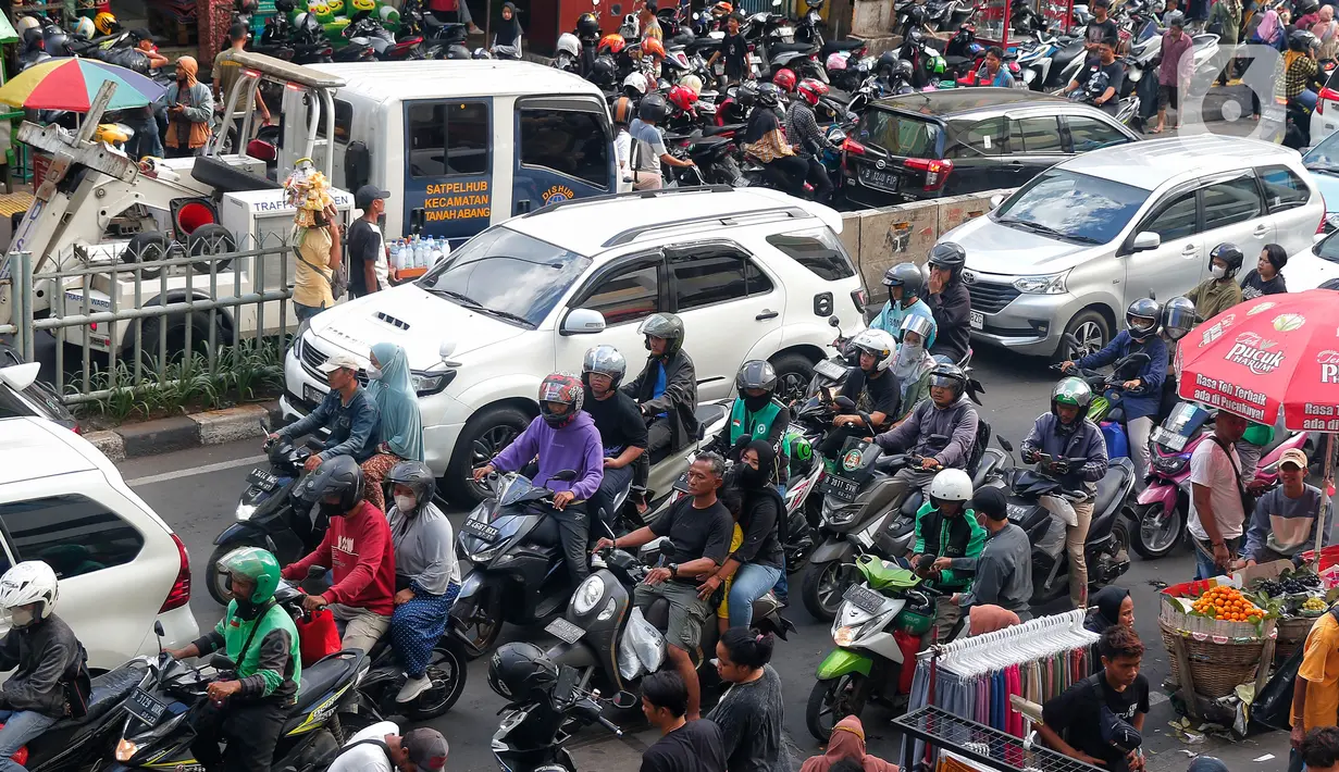 Meningkatnya pengunjung Pasar Tanah Abang untuk berburu pakaian membuat lalu lintas di sekitar Tanah Abang macet karena padatnya pembeli yang terus berdatangan. (Liputan6.com/Angga Yuniar)