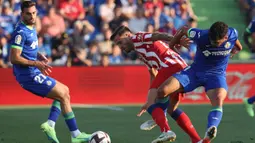 Pemain Atletico Madrid Saul Niguez (tengah) berebut bola dengan pemain Getafe Carles Alena (kanan) pada pertandingan sepak bola Liga Spanyol di Stadion Alfonso Perez Coliseum, Getafe, Spanyol, 15 Agustus 2022. Atletico Madrid menang 3-0. (Thomas COEX/AFP)