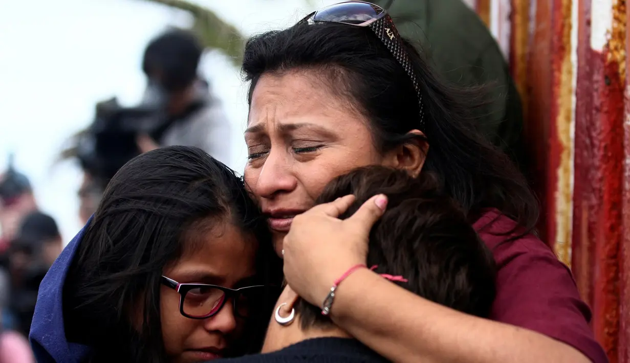Tangis haru seorang ibu saat memeluk anaknya di depan gerbang perbatasan Meksiko dan Amerika Serikat, Tijuana, Meksiko (19/11). Hari Anak Sedunia yang jatuh pada tanggal 20 November ini menjadi momen bertemu dengan keluarga. (Reuters/Jorge Duenes)