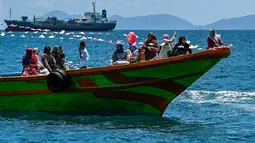 Nelayan yang tergabung dalam wilayah Panglima Laot Lok Kuala Cangkoi bersama warga mengikuti pawai kapal hias pada tradisi kenduri laut di Ulee Lheu, Banda Aceh, Aceh, Rabu (22/7/2026). (AFP/ Chaideer Mahyuddin)