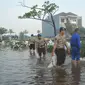 Petugas dibantu warga membetulkan  tanggul yang jebol di kawasan Perumahan Pantai Mutiara, Jakarta, Sabtu (4/6). Akibat tanggul jebol kawasan tersebut tergenang dengan ketinggian 50-60 sentimeter. (Liputan6.com/Gempur M Surya)