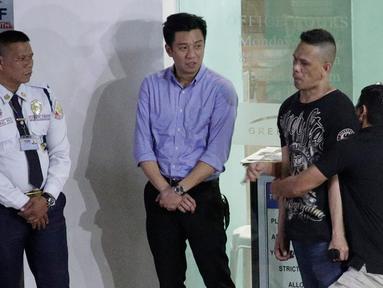 Polisi mendekap pelaku penyenderaan Alchie Paray (kanan) saat sedang berbicara kepada awak media di V-Mall, Manila, Filipina, Senin (2/3/2020). Mantan penjaga mal tersebut menyerahkan diri setelah 10 jam menyendera 30 orang. (AP Photo/Aaron Favila)