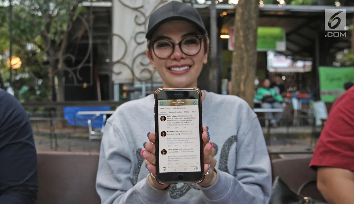 Aktris Nikita Mirzani menunjukkan akun twitter miliknya usai jumpa pers di kawasan Kemang Jakarta, Rabu (4/10). Nikita bertekad menempuh jalur hukum terkait fitnah kabar dirinya menghina Panglima TNI melalui akun Twitternya. (Liputan6.com/Herman Zakharia)