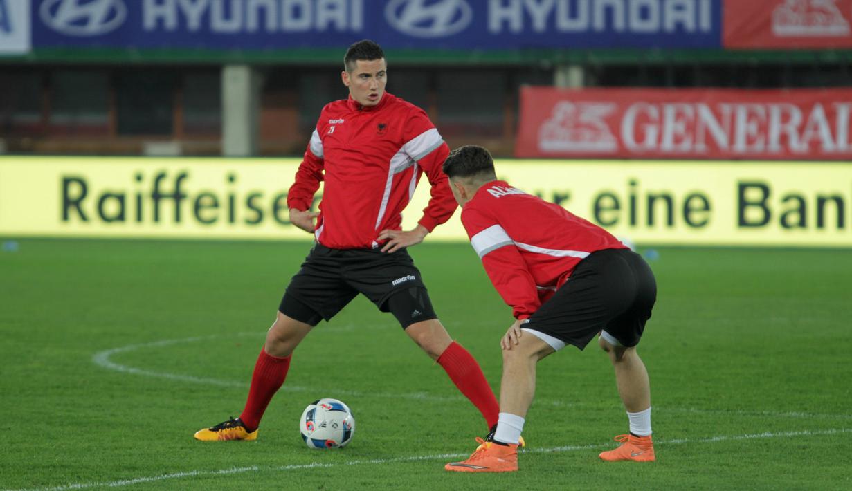 Gelandang Timnas Albania, Odise Roshi (kiri), melakukan pemanasan sambil berbicara dengan Milot Rashica. (Bola.com/Reza Khomaini)