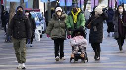 Orang-orang berjalan dalam suhu yang sangat dingin di sepanjang jalan di Seoul, Korea Selatan, Rabu (25/1/2023). Suhu ekstrem tidak hanya melanda Korea Selatan, tetapu juga negara Asia Timur lainnya, seperti Korea Utara, China, dan Jepang. (AP Photo/Ahn Young-joon)