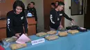Petugas menata barang bukti saat merilis kasus narkoba di  Polres Pelabuhan Tanjung Priok, Jakarta, Selasa (29/12). Barang bukti yang berhasil diamankan petugas pada kasus pencurian narkoba berupa ganja seberat 7,5 kg. (Liputan6.com/Gempur M Surya)