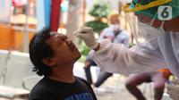 Petugas medis mengambil sampel lendir penumpang bus AKAP untuk tes cepat antigen di terminal Kalideres, Jakarta, Barat, Senin (17/5/2021). Menyambut arus balik, pemudik yang tiba di terminal tersebut diarahkan petugas untuk melakukan tes COVID-19. (Liputan6.com/Angga Yuniar)