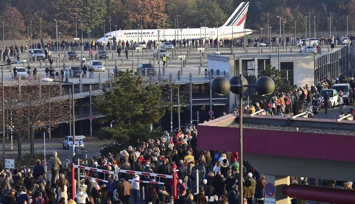 Penonton menyaksikan pesawat Air France melaju ke landasan pacu sebelum lepas landas terakhir dari bandara Tegel di Berlin, Jerman, Minggu (8/11/2020). Bandara Tegel Berlin akhirnya ditutup untuk selamanya pada hari Minggu (1/11) setelah beroperasi lebih dari 60 tahun. (John MACDOUGALL/Pool via AP)