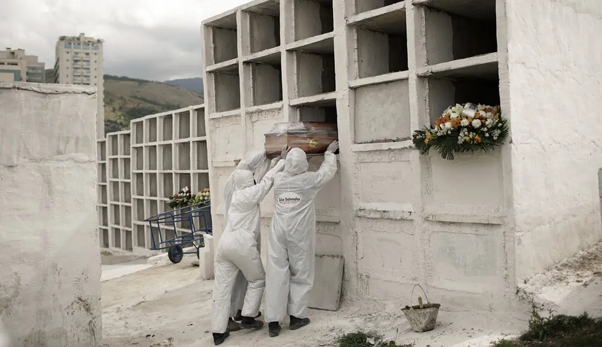 Petugas pemakaman menempatkan peti mati berisi jenazah pasien COVID-19 Jose de Arimateia, 65, ke dalam makam di Nova Iguacu, Brasil, 24 September 2020. Menurut perhitungan Reuters pada September, rata-rata lebih dari 5.400 warga dunia meninggal setiap 24 jam. (AP Photo/Silvia Izquierdo, File)