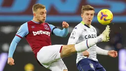 Striker West Ham United, Jarrod Bowen, berebut bola dengan bek Aston Villa, Matt Targett, pada laga lanjutan Liga Inggris di Stadium of London, Selasa (1/12/2020) dini hari WIB. West Ham menang 2-1 atas Aston Villa. (AFP/Julian Finney/pool)