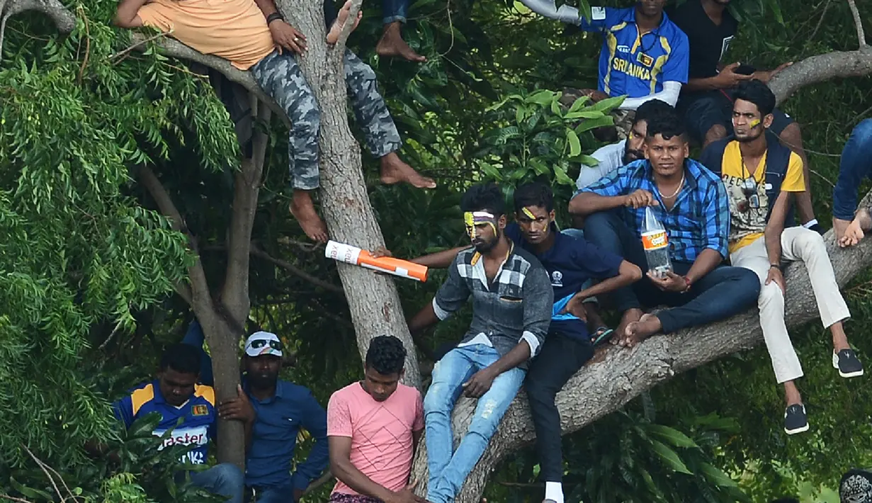Ekspresi suporter Sri Lanka saat menyaksikan pertandingan kriket antara Sri Lanka dan India  pada One Day International (ODI) di Stadion Kriket Internasional Rangiri Dambulla di Dambulla (20/8). (AFP Photo/Lakruwan Wanniarachchi)