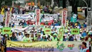 Pengunjuk rasa membawa berbagai atribut saat ambil bagian dalam peringatan May Day 2016 atau Hari Buruh Sedunia di Medellin, Kolombia, Minggu (1/5). Di beberapa negara, peringatan buruh sempat diwarnai dengan aksi bentrok. (REUTERS/Fredy Builes)