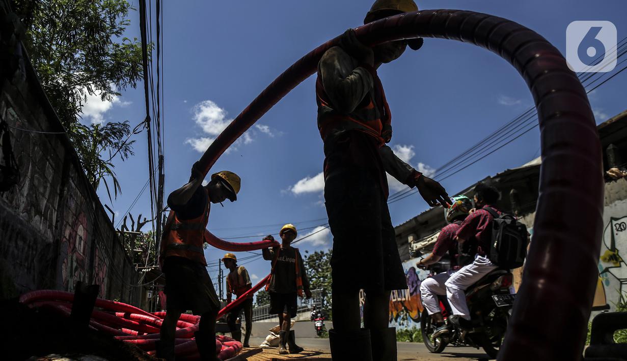 Pekerja informal melakukan pengerjaan menarik kabel di Jakarta, Kamis (2/12/2021). Kemnaker memiliki komitmen serta perhatian tinggi terhadap penanganan dan perlindungan tenaga kerja pada sektor formal dan informal pada masa pandemi Covid-19. (Liputan6.com/Johan Tallo)