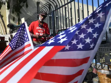 Bendera Amerika Serikat (AS) dikibarkan di tempat tinggal veteran yang bernama Kendrick Bailey di Los Angeles, California (10/11). Kendrick Bailey merupakan veteran AS yang pernah bertugas di Vietnam. (AFP Photo/Frederic J. Brown)