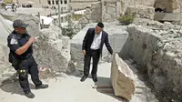 Petugas keamanan dan seorang Yahudi Ortodoks memeriksa sebuah batu besar yang jatuh dari Tembok Ratapan dua hari sebelumnya di Kota Tua Yerusalem, Rabu (25/7). Bongkahan batu itu nyaris menimpa seorang peziarah yang sedang berdoa. (AFP/AHMAD GHARABLI)