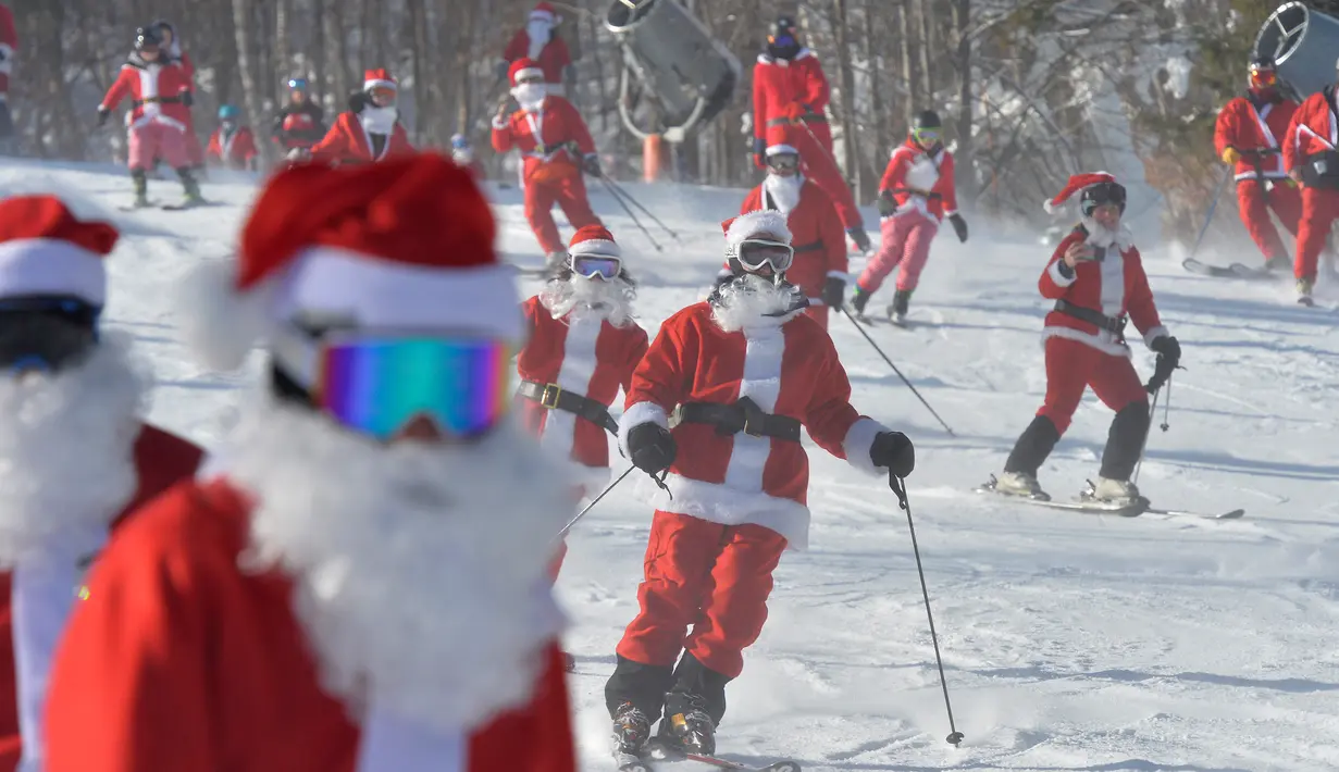 Para pemain ski berpakaian seperti Sinterklas meluncur selama berpartisipasi dalam acara tahunan Santa Sunday di Sunday River Resort yang terletak di Kota Newry, Amerika Serikat, Minggu (8/12/2019). Santa Sunday merupakan acara amal tahunan untuk River Fund Charity. (Joseph Prezioso / AFP)