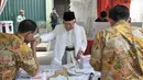 Calon wakil presiden no urut 01 Ma’ruf Amin saat mengambil surat suara di TPS 051 Koja, Tanjung Priok, Jakarta, Rabu (17/4). Ma’ruf Amin tiba bersama keluarga menggunakan baju koko putih, kopiah, sorban, dan sarung berwarna yang sama. (merdeka.com/Iqbal S. Nugroho)