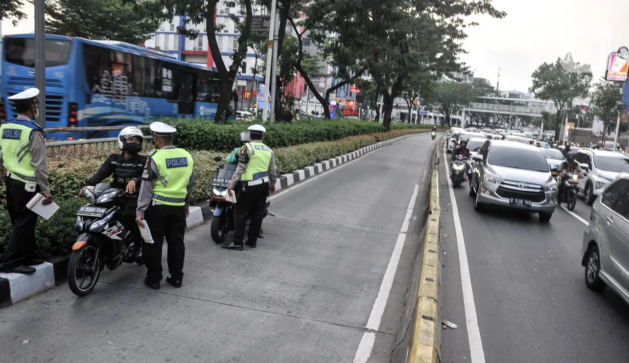 Anggota Satlantas Polres Metro Jakarta Pusat memberhentikan pengendara yang menerobos jalur Bus Transjakarta di Jalan Kramat Raya, Kecamatan Senen, Jakarta, Kamis (21/7/2022). Razia digelar untuk menindak para pengendara yang tidak disiplin demi menghindari kemacetan serta mencegah terjadi kecelakaan di jalur Bus Transjakarta. (merdeka.com/Iqbal S. Nugroho)
