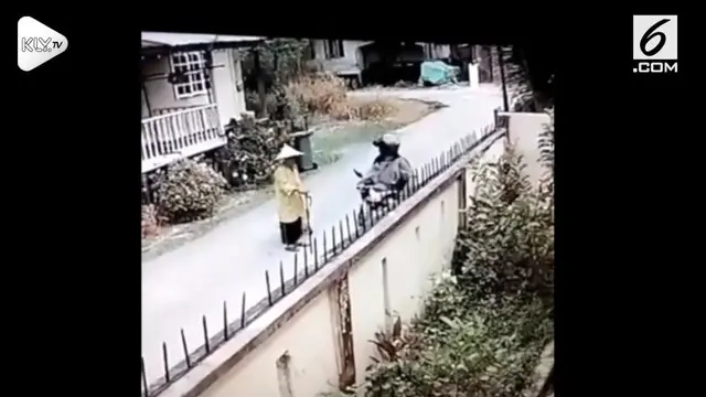 Seorang pengendara motor tertangkap kamera sedang menjambret seorang lansia.