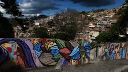 Warna-warni mural menghiasi tembok di permukiman kumuh Petare di Caracas pada 29 Mei 2019. Petare yang merupakan kawasan kumuh terbesar di Venezuela menjadi rumah bagi lebih dari 500.000 jiwa. (Photo by MARVIN RECINOS / AFP)
