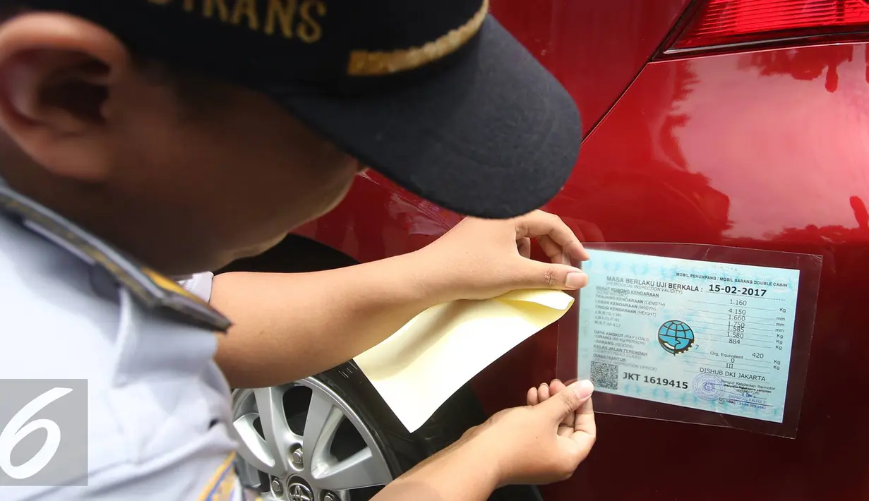 Petugas memasang kir mobil peserta saat tes uji SIM dan kir transportasi online di Jakarta, (15/8). Kegiatan diadakan menyambut HUT Kemerdekaan RI ke-71 serta menciptakan layanan angkutan umum yang prima dan accountable. (Liputan6.com/Immanuel Antonius)