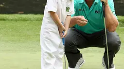 Pegolf Amerika Serikat, Charley Hoffman melihat putrinya, Katelyn memukul bola ketika hari terakhir mengikuti latihan untuk turnamen golf Masters 2018 di Augusta, Georgia, Rabu (4/4). (JAMIE Squire / Getty Images / AFP)