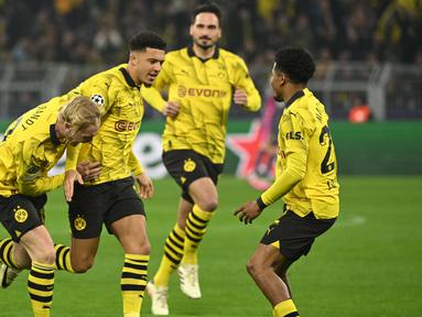 Gelandang Borussia Dortmund, Jadon Sancho (kedua kiri) berselebrasi usai mencetak gol pembuka saat pertandingan sepak bola leg kedua babak 16 besar Liga Champions melawan PSV Eindhoven di Stadion Signal Iduna, Dortmund, Jerman, 13 Maret 2024. (INA FASSBENDER/AFP)