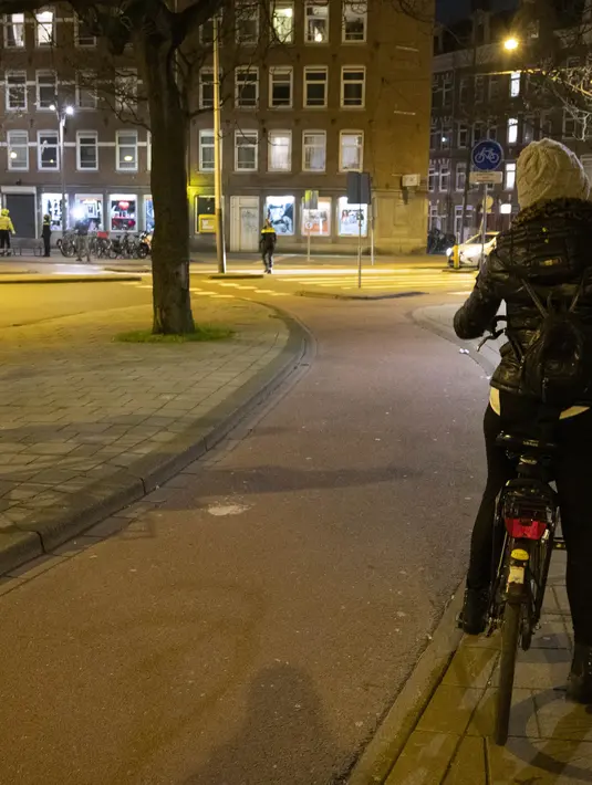 Polisi mengontrol sertifikasi keluar pada orang yang lewat saat jam malam dimulai di Haarlem, Belanda (23/1/2021). Mulai 23 Januari, jam malam dimulai di Belanda dari pukul 21.00 hingga 04.30 untuk mengendalikan tingkat infeksi COVID-19. (AFP/ANP/Koen van Weel)