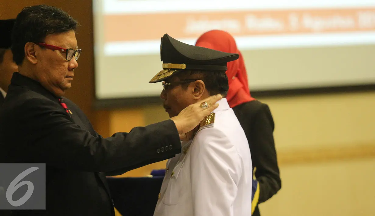 Tjahjo Kumolo (kiri) menyematkan lencana kepada Penjabat Gubernur Jambi Irman di Kemendagri, Jakarta, Rabu (5/8/2015). Irman sebelumnya menjabat Staf Ahli Bidang Aparatur Kemendagri menggantikan Hasan Basri Agus. (Liputan6.com/Faizal Fanani)
