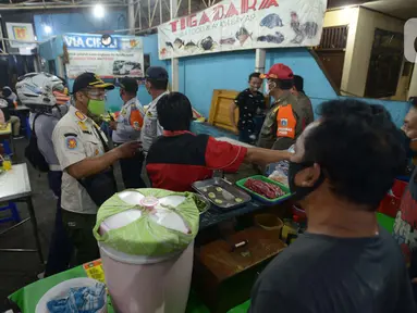 Petugas Gabungan melakukan penertiban penerapan PSBB tempat makan yang masih menyediakan tempat konsumen di wilayah Kecamatan Pulogadung, Jakarta, Jumat (18/9/2020). Malam, Razia dilakukan memastikan ketidakadaannya konsumen makan ditempat tersebut. (merdeka.com/Imam Buhori)