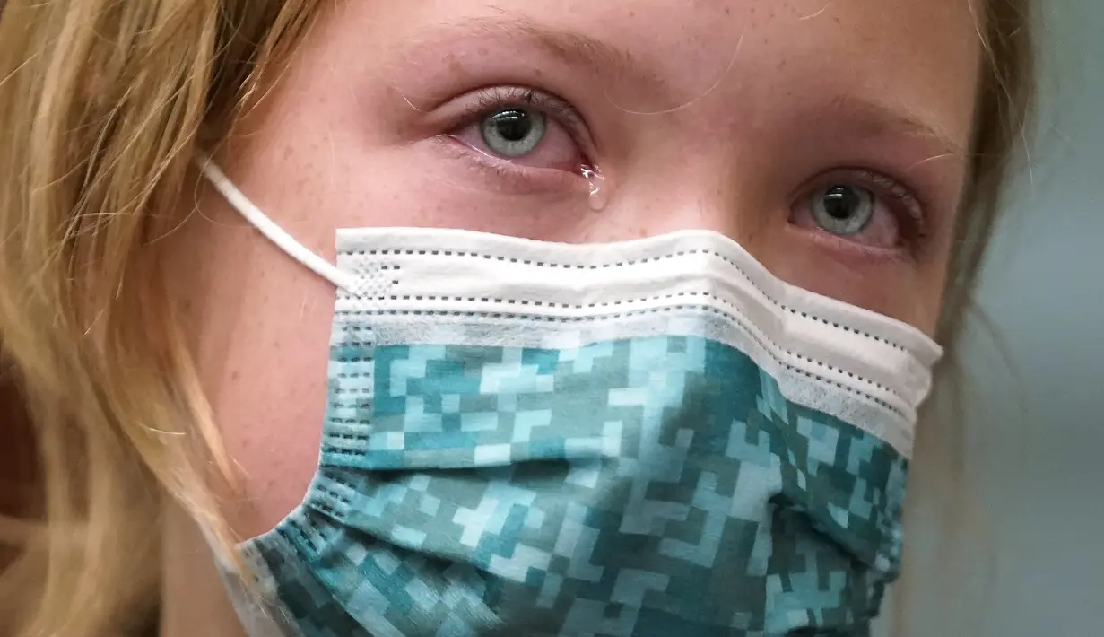 Nina Miller (9) meneteskan air mata sebelum disuntik vaksin COVID-19 pada hari pertama vaksinasi untuk anak 5 - 11 tahun di South Salt Lake, Utah, Rabu (3/11/2021). Ini menjadi langkah perdana vaksinasi Covid-19 bagi anak kecil di Amerika Serikat. (AP Photo /Rick Bowmer)