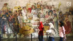 Pengunjung melintasi lukisan yang ada di Museum Fatahillah dan Museum Wayang, Kota Tua, Jakarta, Selasa (26/6). Pemprov DKI menggratiskan biaya masuk sejumlah museum menyambut HUT ke-491 Jakarta. (Liputan6.com/Arya Manggala)