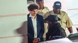 Pendiri FTX Sam Bankman-Fried (kiri) dibawa pergi dengan tangan diborgol oleh petugas Kepolisian Kerajaan Bahama di Nassau, Bahamas, 13 Desember 2022. Berita penangkapan ini tentunya tidak mengejutkan, mengingat pada Jumat lalu, Departemen Kehakiman mengatakan bahwa pihaknya terus memantau kebangkrutan FTX, yang diperkirakan akan merugikan lebih dari satu juta orang. (Mario Duncanson/AFP)